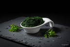 Chlorella Pulver in weißer Keramikschale auf Schieferplatte, KI-generiert